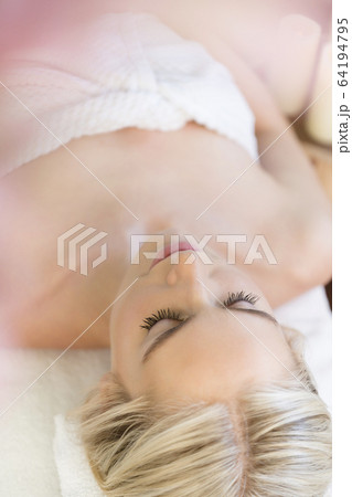 Woman relaxing lying on back on massage table Woman relaxing lying on back on massage table 64194795