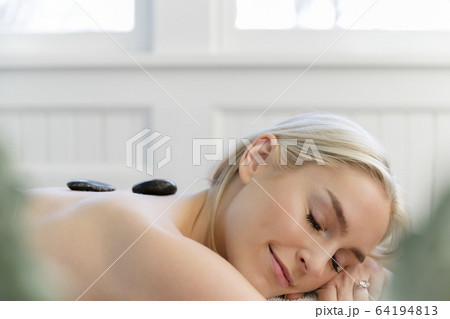 Woman enjoying hot stone massage 64194813