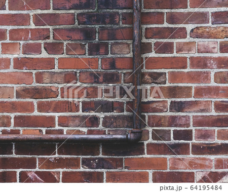 Gas utility pipe against brick wall 64195484