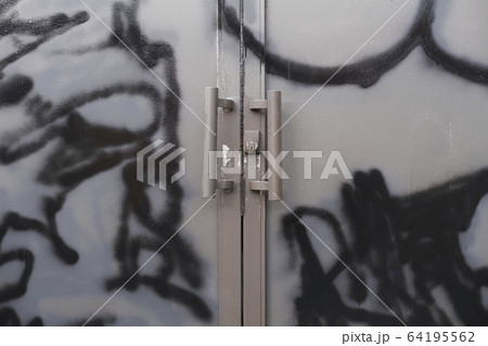 Graffiti and paint covered doorway of abandoned office building 64195562