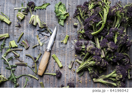High angle close up of purple sprouting broccoli and knife with wooden handle. 64196042