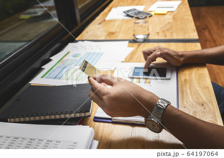 Businessman holding credit card and using smartphone. Businessman holding credit card and using smartphone. 64197064
