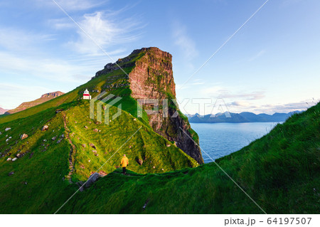 Kallur lighthouse on green hills of Kalsoy island 64197507