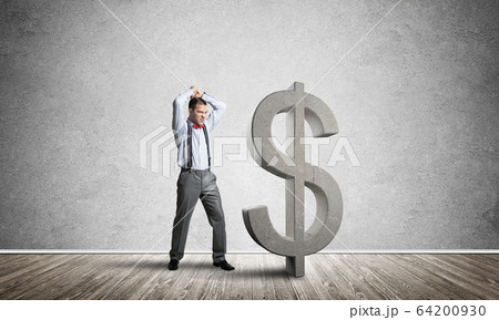 Determined banker man in empty concrete room breaking dollar figure Determined banker man in empty concrete room breaking dollar figure 64200930