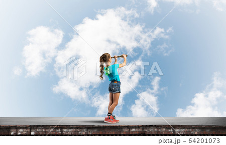 Concept of careless happy childhood with girl exploring this world 64201073