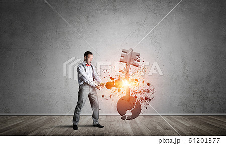 Breaking through access concept with man in room crashing concrete key 64201377