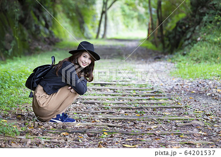 兵庫県武田尾廃線跡のハイキングコースを散策する帽子をかぶつた若い女性 64201537