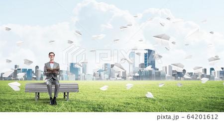 Young businessman or student studying the science and paper planes flying around Young businessman or student studying the science and paper planes flying around 64201612