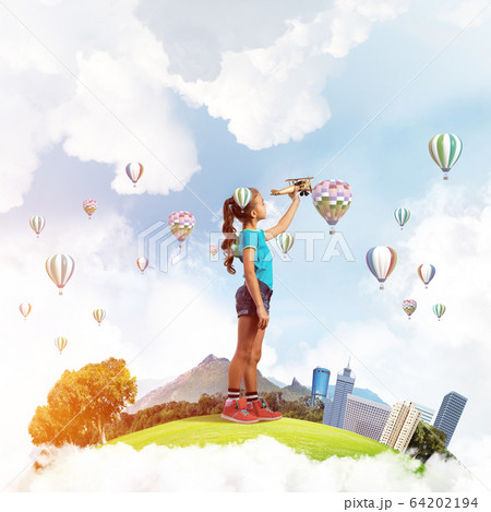 Concept of careless happy childhood with girl dreaming to become pilot Concept of careless happy childhood with girl dreaming to become pilot 64202194