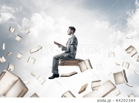 Man reading book and many of them flying in air 64202384