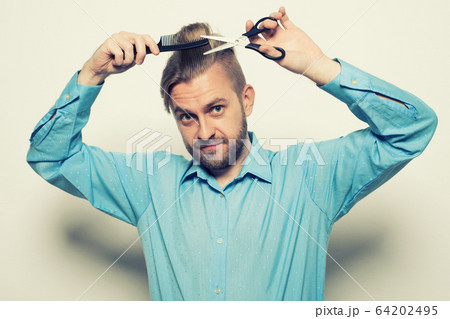 attractive male hairdresser shears himself with attractive male hairdresser shears himself with 64202495