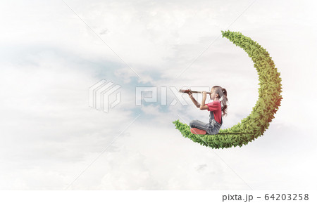 Concept of careless happy childhood with girl on green moon Concept of careless happy childhood with girl on green moon 64203258