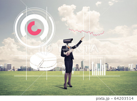 Camera headed woman standing on green grass against modern citys 64203514