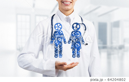Close of female medicine worker showing in palm gear couple figures Close of female medicine worker showing in palm gear couple figures 64204802