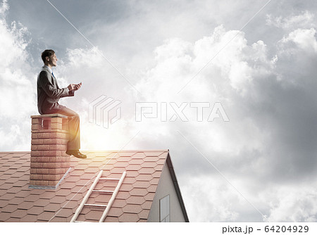 Student guy in suit on brick house roof reading book Student guy in suit on brick house roof reading book 64204929