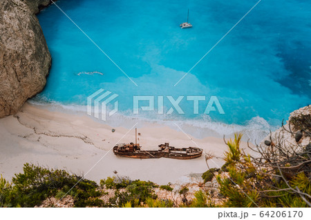 Shipwreck on Navagio beach. Azure turquoise sea water and paradise sandy beach in evening light. Famous tourist visiting landmark on Zakynthos island, Greece Shipwreck on Navagio beach. Azure turquoise sea water and paradise sandy beach in evening light. Famous tourist visiting landmark on Zakynthos island, Greece 64206170