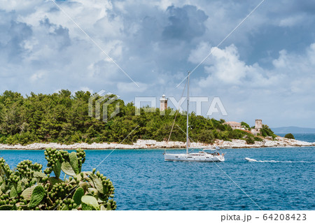 Summer holiday vacation. Kefalonia island, Greece. White sailing boat approaching port of Fiskardo 64208423