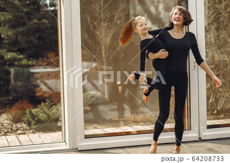 Woman with daughter is engaged in gymnastics 64208733