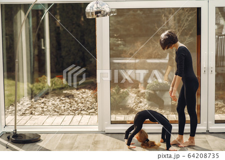 Woman with daughter is engaged in gymnastics 64208735