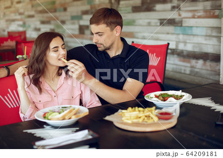 Beautiful couple sitting in a summer cafe 64209181