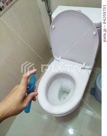 Men's hands use alcohol spray to flush the toilet to disinfect before use. 64209701