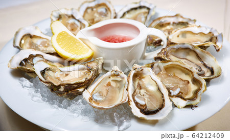 Fresh oysters on ice with lemon close up. Shallow dof. 64212409