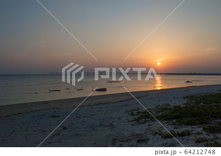 オレンジ色の夕日と飛行場の誘導灯と砂浜 64212748