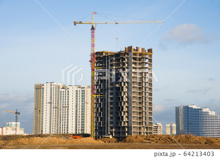 Tower cranes working at construction site against blue sky 64213403