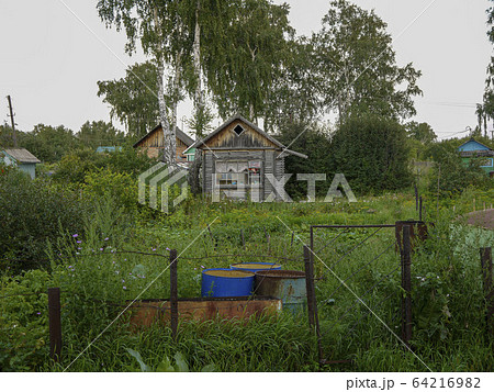 Old small house on the edge of the village. Holidays in ecological places in the nature far from big cities. Calm time after defeating the virus. 64216982