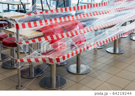 Closeup of chairs up-ended on the tables at cafe due to quarantine Closeup of chairs up-ended on the tables at cafe due to quarantine 64219244