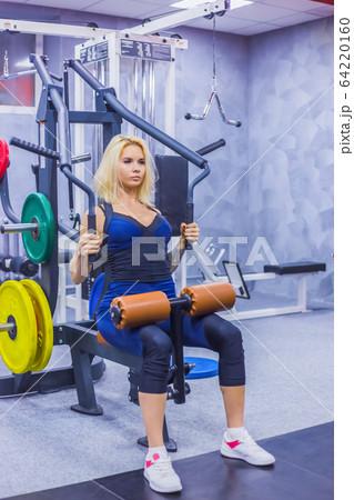 Athletic young woman working out on fitness exercise equipment 64220160
