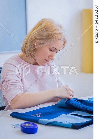 Woman tailor measuring suit jacket for sewing at atelier - fashion concept 64220207