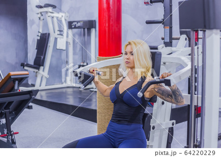 Athletic young woman working out on fitness exercise equipment Athletic young woman working out on fitness exercise equipment 64220229