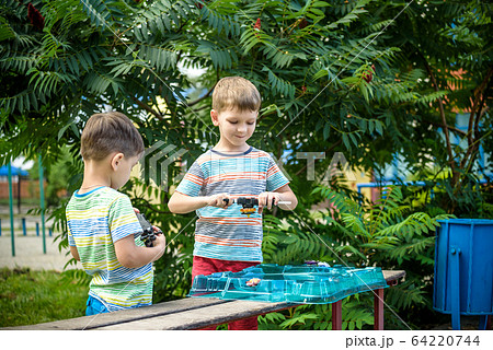 Two boys playing with a spinning top kid toy. Two boys playing with a spinning top kid toy. 64220744