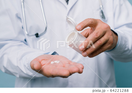 Pills in the doctor's hand. Panacea for all diseases Pills in the doctor's hand. Panacea for all diseases 64221288