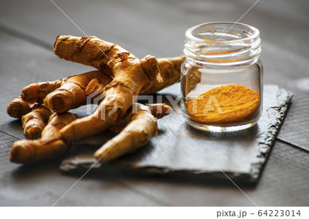 turmeric powder and fresh turmeric root 64223014