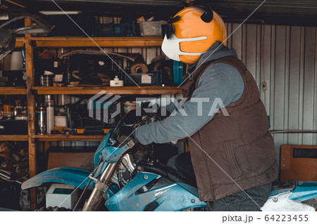 Emoji motocross rider with fancy black nerd sunglasses on his motorcycle inside of garage . Emoji with mask protecting against coronavirus Covid 19. 3D rendering and photography collage. Emoji motocross rider with fancy black nerd sunglasses on his motorcycle inside of garage . Emoji with mask protecting against coronavirus Covid 19. 3D rendering and photography collage. 64223455