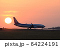 離陸に向かう飛行機と夕日　熊本空港 64224191