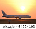 離陸に向かう飛行機と夕日　熊本空港 64224193