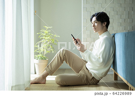 男性　モデル　座る　ニット　スマホ　スマートフォン 64226989