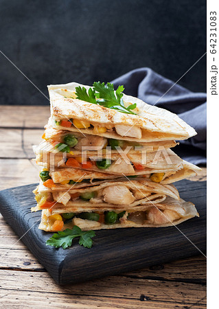 Triangular slices of a Mexican quesadilla with the Triangular slices of a Mexican quesadilla with the 64231083
