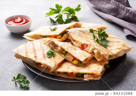 Triangular slices of a Mexican quesadilla with the Triangular slices of a Mexican quesadilla with the 64231088