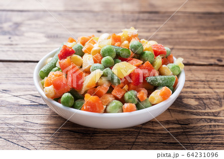 Chopped frozen vegetables in a plate on a wooden 64231096