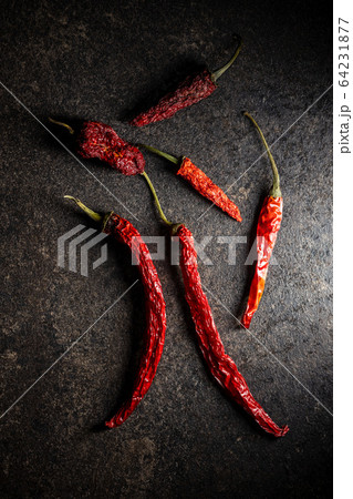 Dried red chili peppers on black table. 64231877