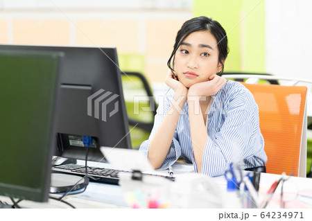 オフィスで落ち込む若い女性社員 オフィスで落ち込む若い女性社員 64234971