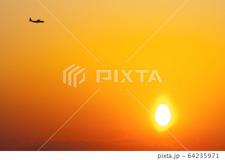 夕暮の中を飛行するC-130ハーキュリーズ 64235971