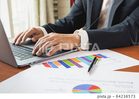 Businessman working with laptop with graph stock chart on table work from home concept. Businessman working with laptop with graph stock chart on table work from home concept. 64236573
