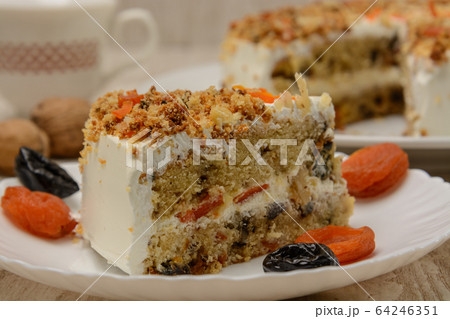 Fruit cake, a piece on a plate with dried fruits. Wood background 64246351