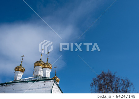 Golden domes with crosses of a white stone church Golden domes with crosses of a white stone church 64247149