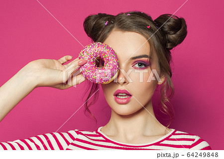 Fashion model woman holding donut on vivid pink 64249848